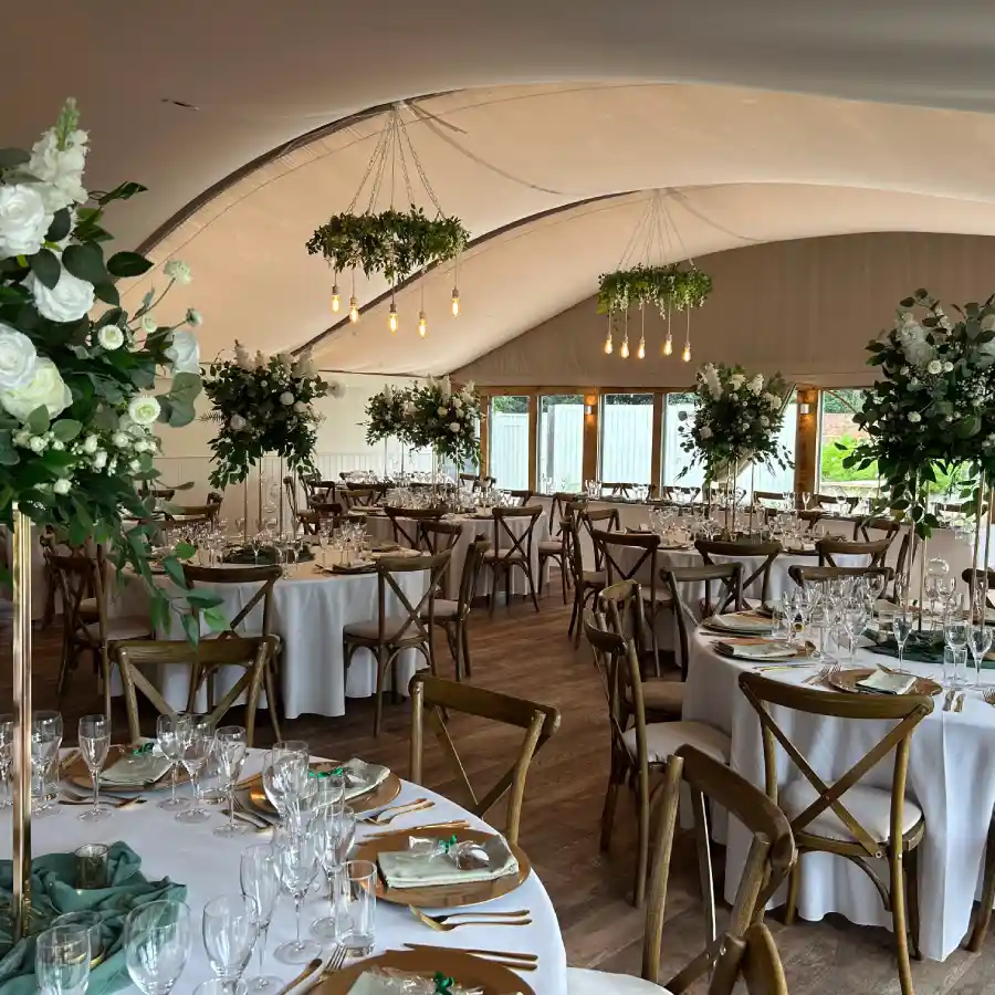 Wedding marquee styled with hanging florals above round tables