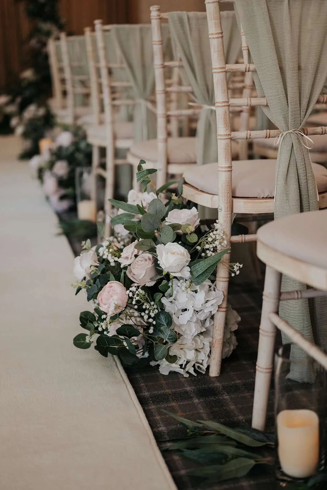 White and green meadow arrangement at the end of a row of chairs