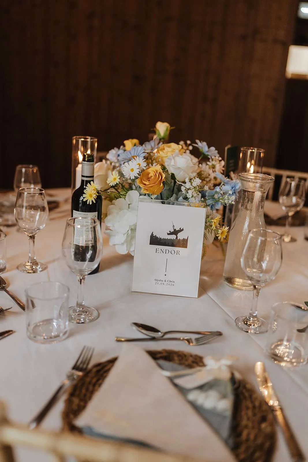 Footed bowl of pale blue, yellow and white blooms on a round table