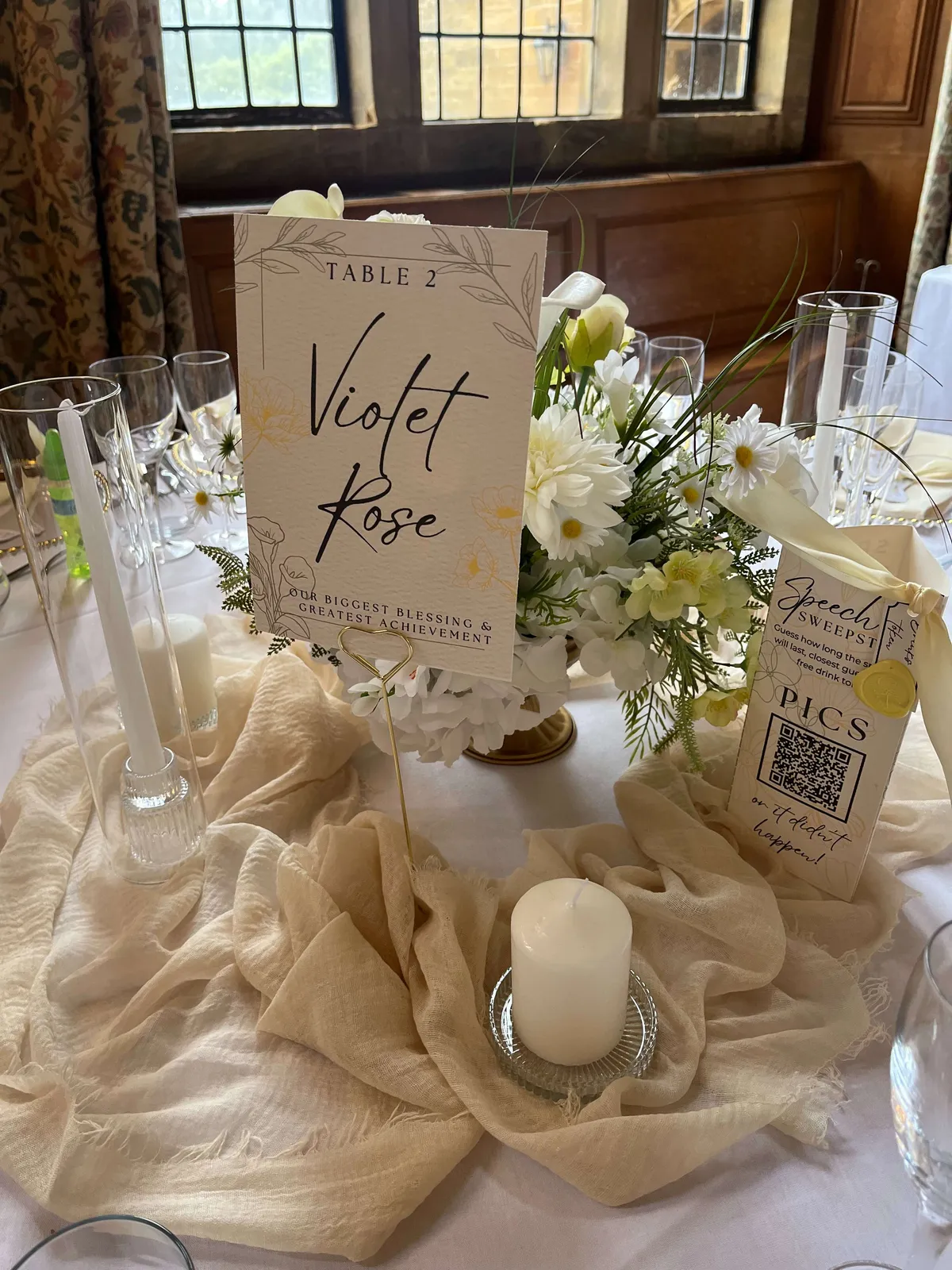 White and green footed bowl arrangement on a table draped with ivory fabric