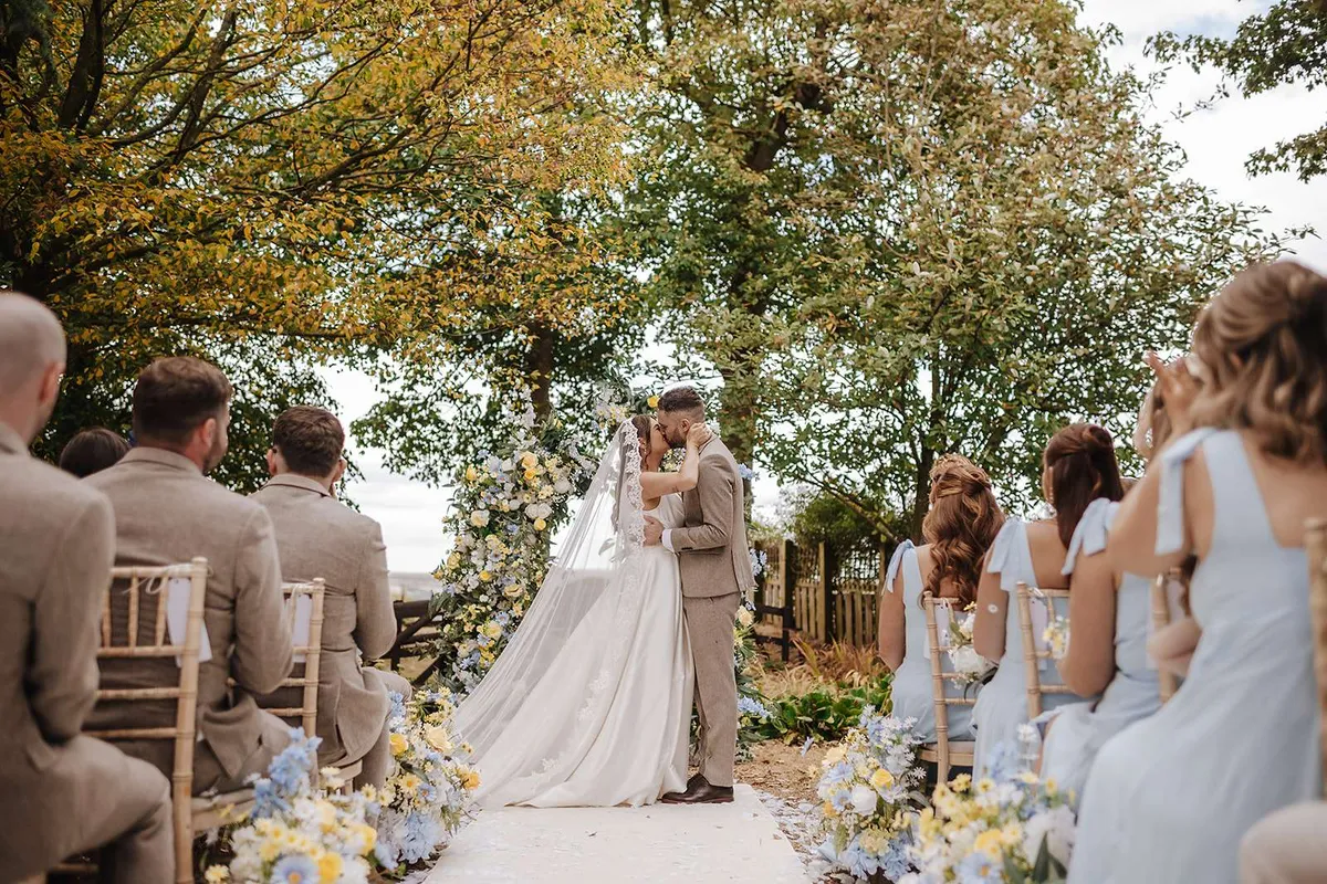 Outdoor courtyard ceremony with soft blue and white florals