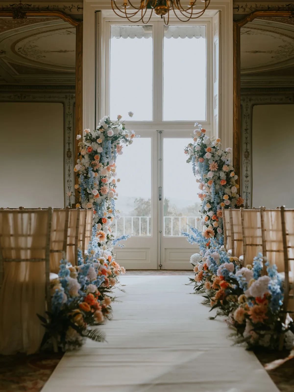 Pastel blue and peach floral pillars framing a tall window at Kingston Maurward