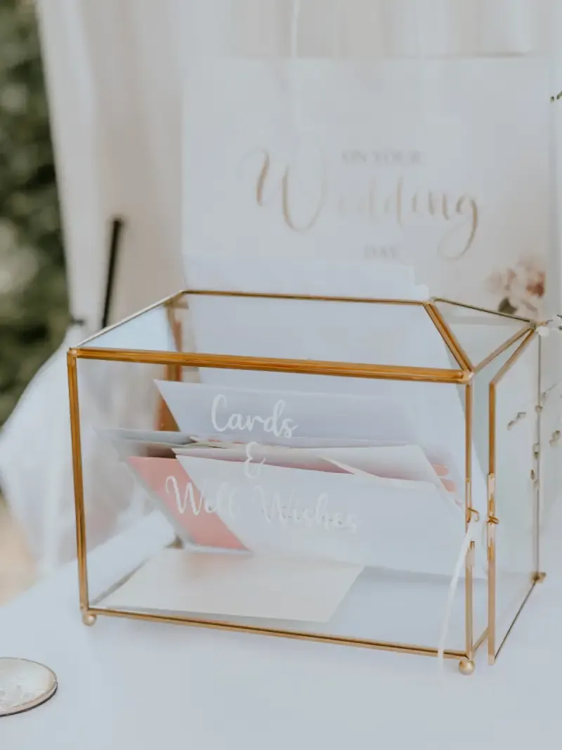 Gold-framed glass card box on a white table